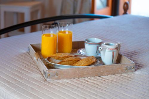 a tray with two glasses of orange juice and a plate of food at Madalena's Summer House in Adamantas