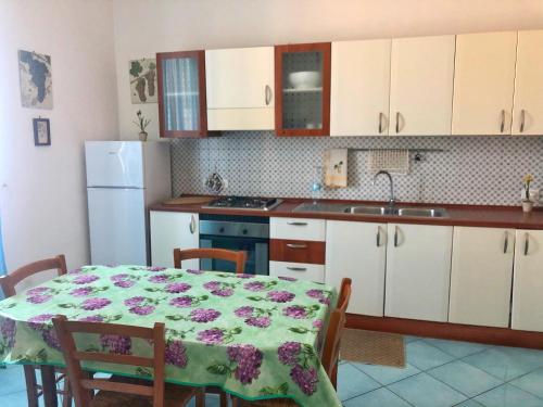 kuchnia ze stołem i kuchnia z białymi szafkami w obiekcie Residenza Celeste al 28 w mieście Ischia