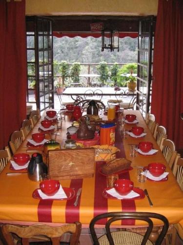 une longue table en bois avec des plats rouges dans l'établissement La Figuera, à Castelnou