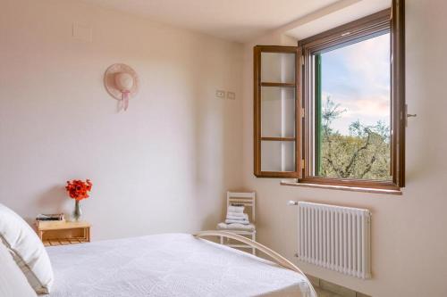 een witte slaapkamer met een bed en een raam bij Agriturismo La Casina nel Vigneto in Larciano