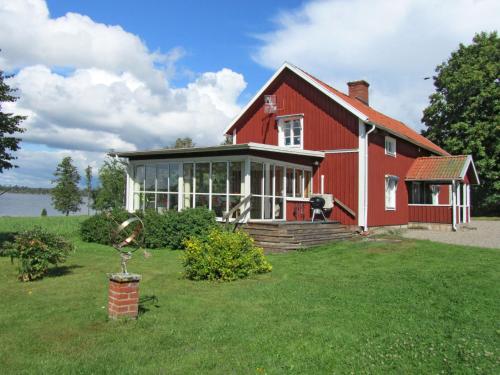 a red barn with a yard with a house at Chalet Stora Gryten by Interhome in Askersund