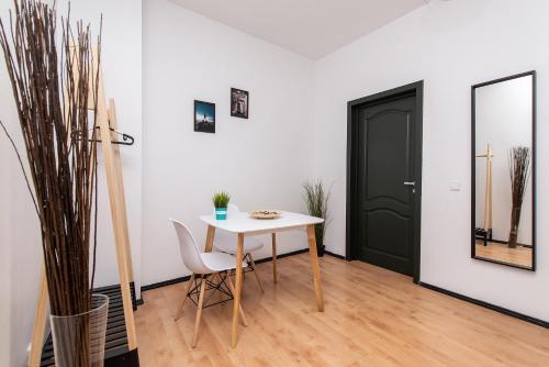 a white table and chairs in a room with a black door at The house Vilnius in Vilnius