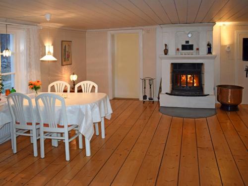 a living room with a table and a fireplace at Chalet Stora Gryten - NAK035 by Interhome in Askersund