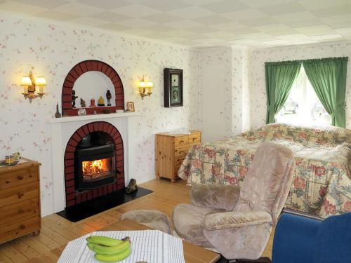 a bedroom with a fireplace and a bed and a chair at Chalet Ramsjö by Interhome in Ramsjö