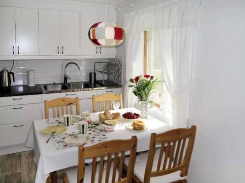 een witte keuken met een tafel met eten erop bij Chalet Ramsjö - HSL020 by Interhome in Ramsjö