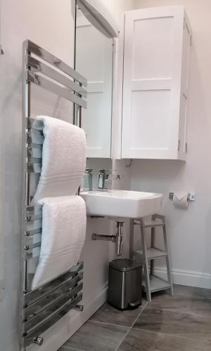 a bathroom with a sink and a mirror and towels at The Old Bakery - 11A in Berkeley