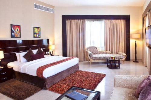 a hotel room with a large bed and a couch at Landmark Riqqa Hotel in Dubai