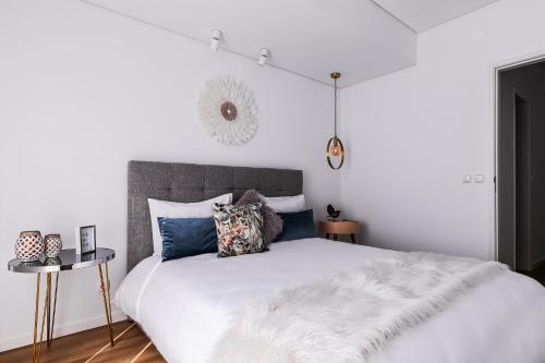 a bedroom with a large white bed with pillows at Kerala 49, Deluxe Flat in Historic Center in Peniche