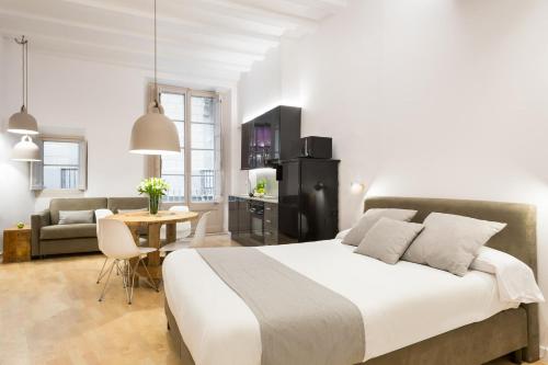 a bedroom with a large bed and a living room at Ola Living CND Canuda in Barcelona