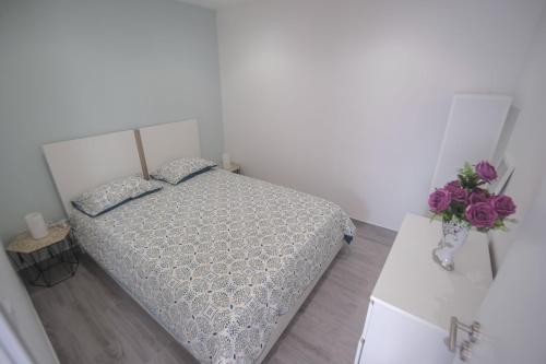 a bedroom with a bed and a vase of flowers at Casa Ganga in Nazaré