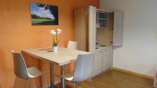a kitchen with a table with chairs and a sink at Turin Airport Hotel & Residence in San Francesco al Campo