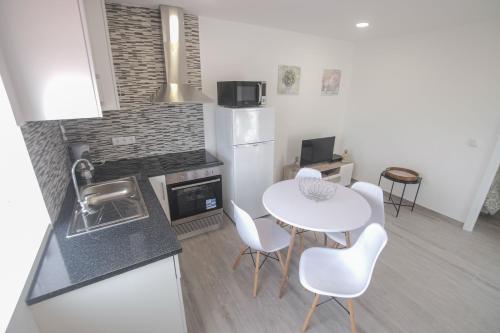 a kitchen with a white table and chairs in a kitchen at Casa Ganga in Nazaré