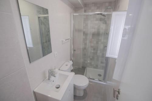 a bathroom with a toilet and a sink and a shower at Casa Ganga in Nazaré