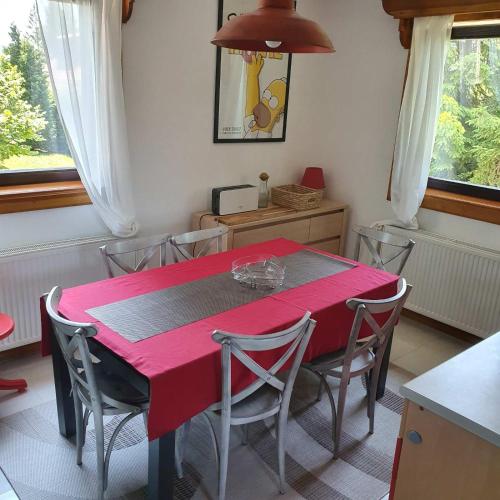 a dining room with a red table and chairs at Planinska kuća sa dvorištem in Zlatibor