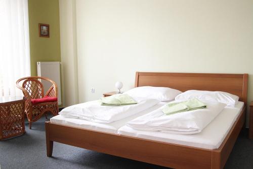 a bedroom with a bed with white sheets and pillows at Milotín in Zuberec