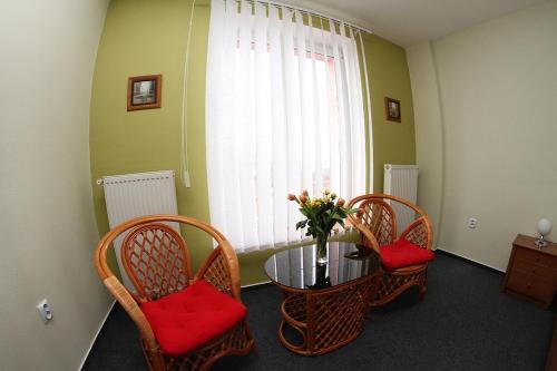 a room with a table and chairs and a vase with flowers at Milotín in Zuberec