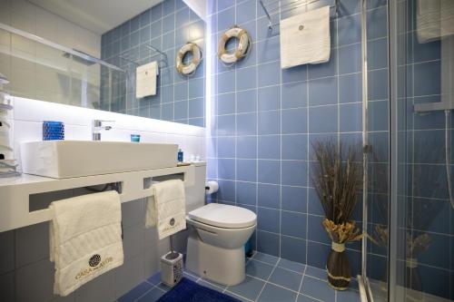 a blue tiled bathroom with a toilet and a sink at Casa dos Avós- Douro in Peso da Régua