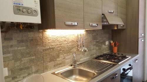 uma cozinha com um lavatório e um fogão em DaNicolas Cairoli Apartment em Monza