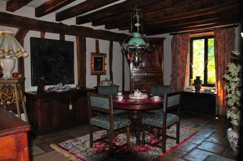 a dining room with a table and chairs and a chandelier at LES GUENINS in Gien