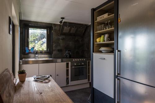 a kitchen with a wooden table and a refrigerator at De Meisjes in Middelburg