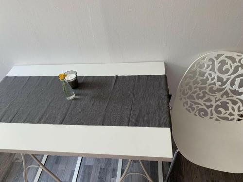 Großes, modernes Apartment im Souterrain في Frensdorf: طاولة بيضاء مع مزهرية فيها ورد