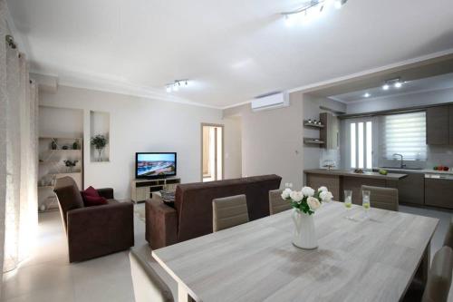 a living room with a table and chairs and a living room at Villa Ligero in Palaiokatoúna