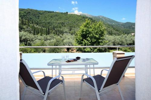 a table and chairs on a balcony with a view at Villa Ligero in Palaiokatoúna
