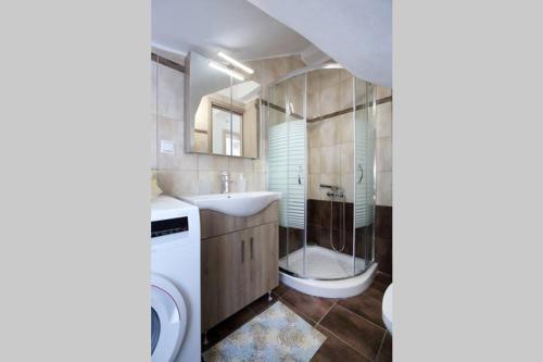 a bathroom with a sink and a washing machine at Villa Ligero in Palaiokatoúna