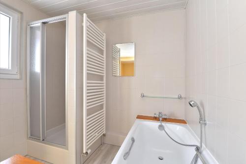 a white bathroom with a tub and a shower at Maison D'hôtes Du Landersbach in Sondernach