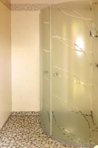 a glass shower door in a room with a tile floor at Holiday Home Munkhalla Morgonsolen by Interhome in Asarum
