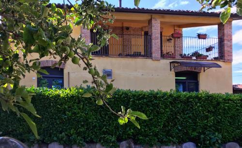 a house with a balcony and a hedge at Agriturismo Il Colore del Grano in San Vittore