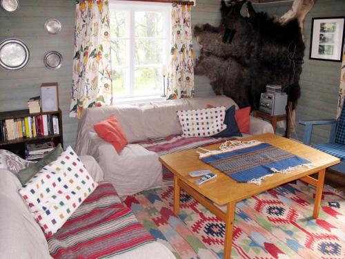 ein Wohnzimmer mit einem Sofa und einem Tisch in der Unterkunft Chalet Storsätern Dyllen by Interhome in Idre