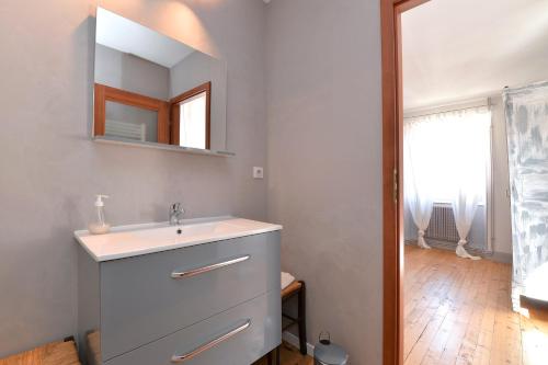 a bathroom with a sink and a mirror at Maison D'hôtes Du Landersbach in Sondernach