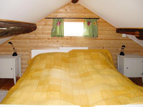 ein Schlafzimmer mit einem gelben Bett in einem Blockhaus in der Unterkunft Chalet Storsätern Dyllen by Interhome in Idre