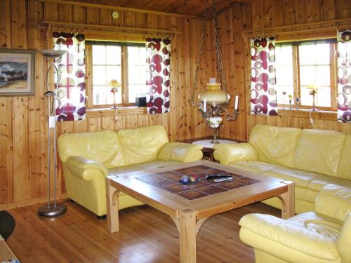a living room with yellow couches and a coffee table at Chalet Vemhån Byn - HJD062 by Interhome in Vemhån