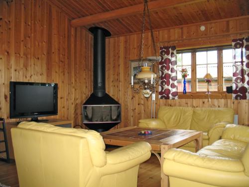 sala de estar con chimenea y sillas amarillas en Chalet Vemhån Byn - HJD062 by Interhome en Vemhån