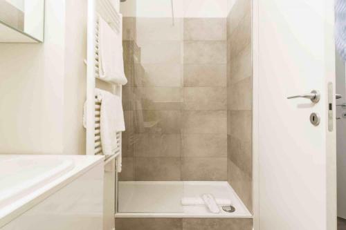 een witte badkamer met een douche en een wastafel bij Contempora Apartments - Cavallotti 13 - B12a in Milaan