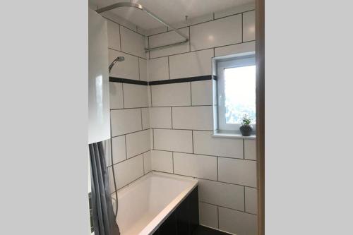 een badkamer met een bad en een raam bij Monteurwohnung in Loiching
