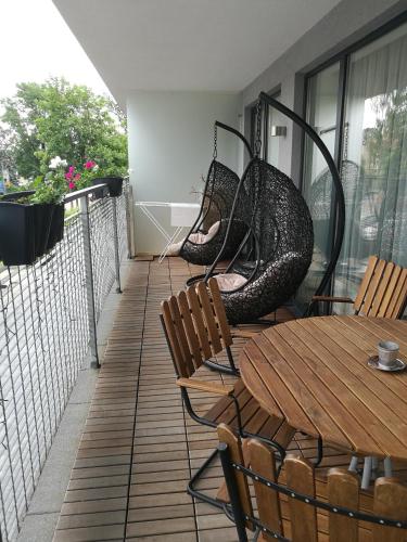 a balcony with chairs and a table and swings at Centro apartamentai in Birštonas