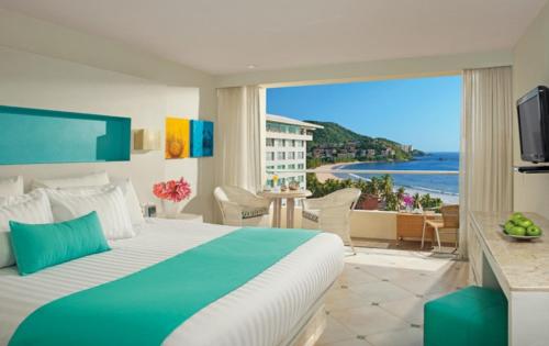 a hotel room with a bed and a view of the ocean at Sunscape Dorado Pacifico Ixtapa Resort & Spa- All Inclusive in Ixtapa