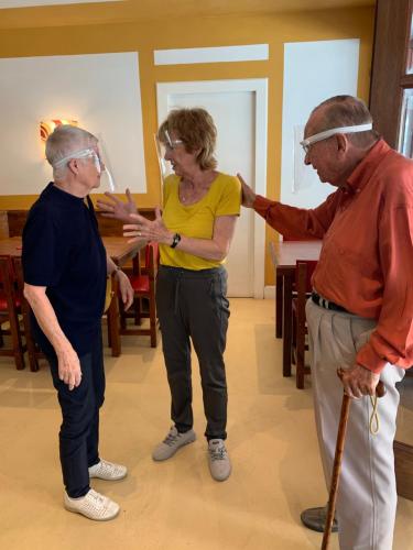 a woman standing between two older men in a room at Pension Casa Austria in Calella
