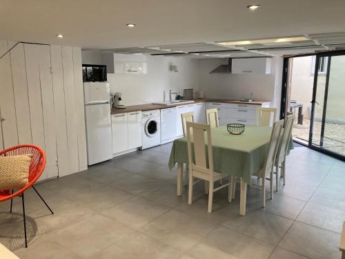 a kitchen and dining room with a table and chairs at Les Locations du Bassin Appartements Alexandre in La Teste-de-Buch