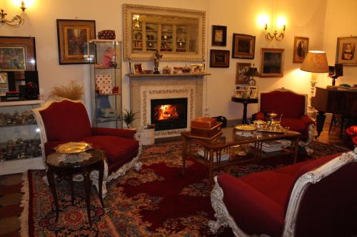a living room with a fireplace and red furniture at Le Terrazze Del Chianti b&b Residenza d'Epoca e di Charme in Tavarnelle in Val di Pesa