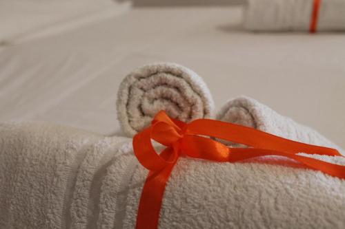 a towel with a red ribbon on a bed at Il Gelso Nero in Vittoria