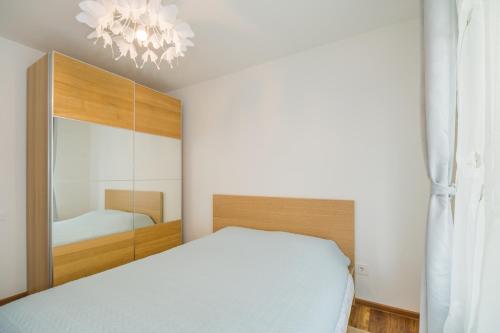 sypialnia z białym łóżkiem i lustrem w obiekcie Modern Central Ap - Terrace - Parking w Braszowie