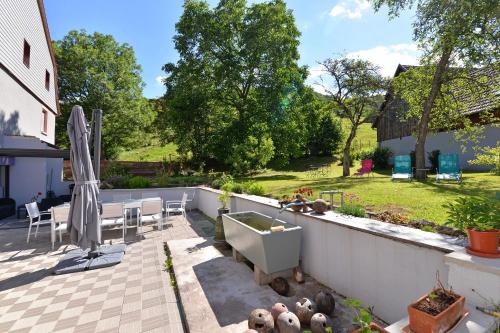 a backyard with a bath tub and a table and chairs at Maison D'hôtes Du Landersbach in Sondernach