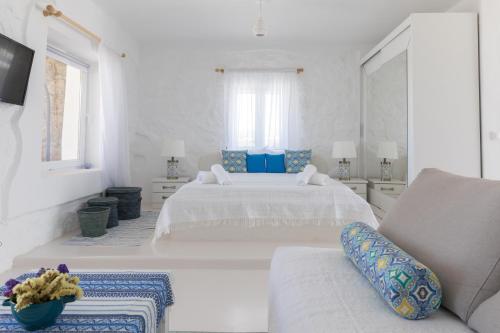 a white bedroom with two beds and a couch at Sugar Blue in Mýkonos City