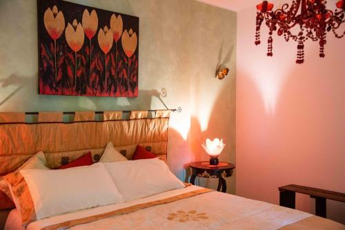 a bedroom with a bed with a painting on the wall at Sogni d'oro in Alberobello