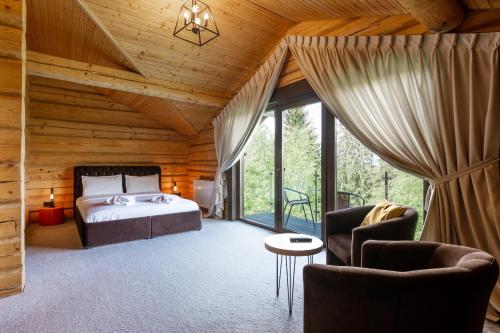 um quarto com uma cama e cadeiras em uma sala em GOOD DAYS Shale Resort 4 км до Буковеля em Yablunytsya