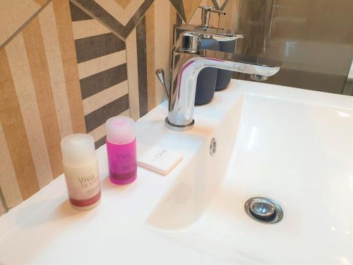 - un lavabo dans la salle de bains avec 2 bouteilles de cosmétiques dans l'établissement STUDIO CENTRE MER 302, à Nice